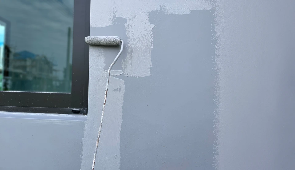 Chantier de peinture extérieure en cours sur façade de bâtiment