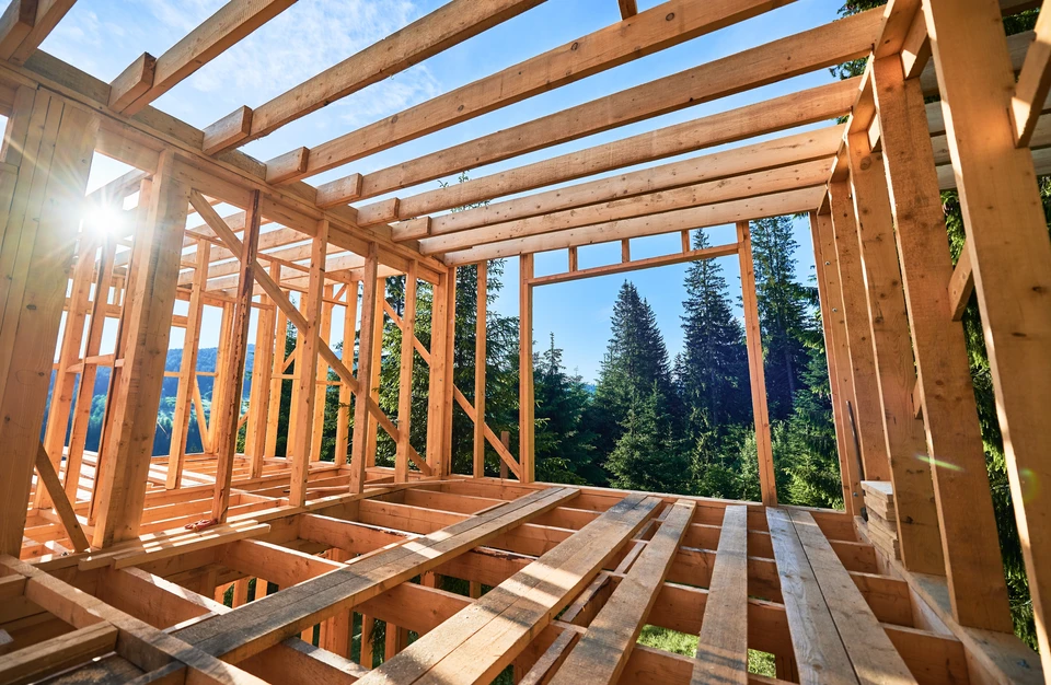 Chantier de construction résidentielle en extérieur avec charpente bois en cours d'assemblage