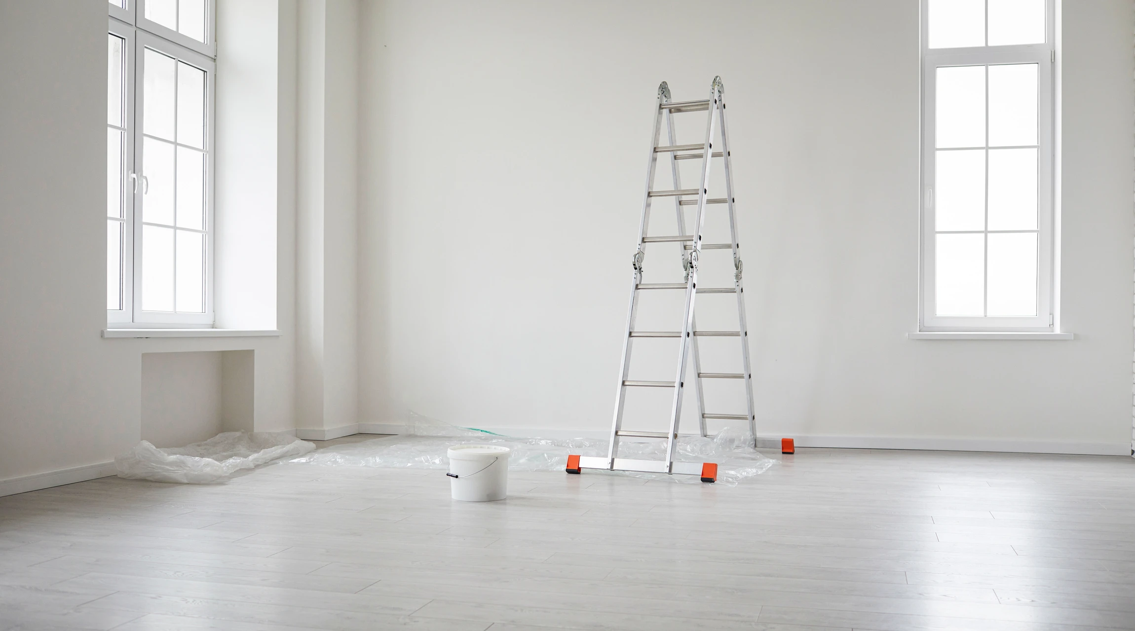 Travailleur professionnel Installant du parquet stratifié ou en bois sur le sol, homme tenant un carrelage en bois à la lumière du soleil