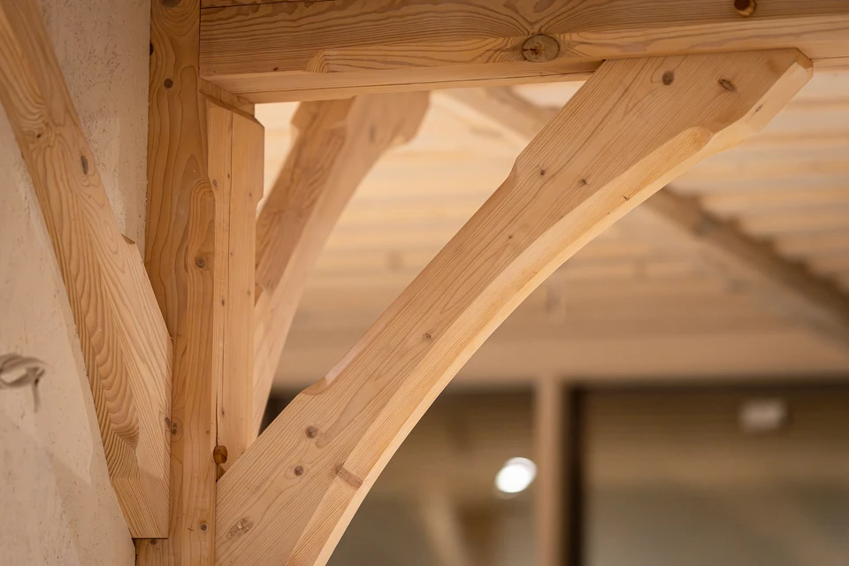 Chantier de construction en bois avec charpentier en gilet haute visibilité orange mesurant une structure